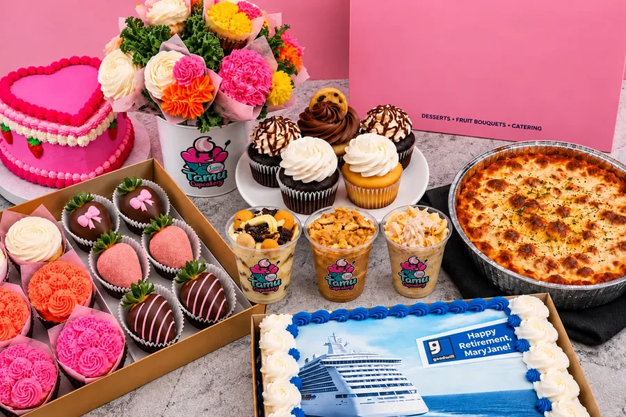 A party spread with a heart cake, a cupcake bouquet, chocolate covered strawberries, rose piped cupcakes, dessert cups and a sheet cake